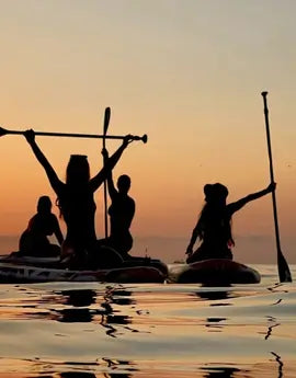 Grupo de personas disfrutando del Amanecer Paddle Surf en Barcelona.